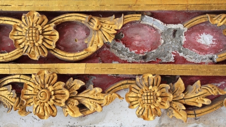 Grunge and broke golden floral sculpture by traditional Thai style on temple wall の写真素材