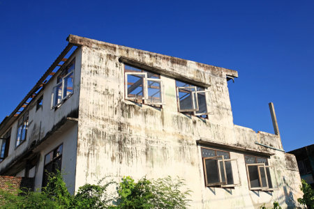 Decaying abandon building against blue sky のeditorial素材