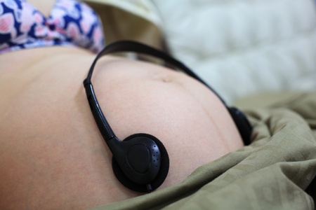 pregnant woman with black headphones to let baby listening mosaic songの写真素材