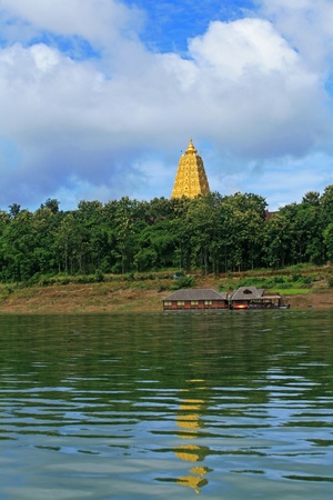 Gold sanctuary pagoda landmark with reflection on the river at Sangklaburi, Thailandの写真素材