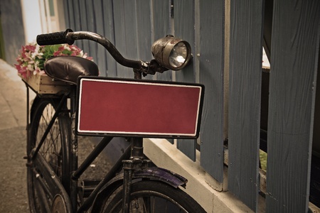 Vintage bicycle with red blank plate near wood wallの写真素材