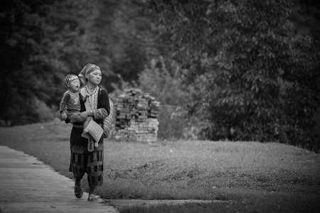 SAPA-JUL 23: Unidentified hill tribe mother with her son walks down from the Red Dao Minority village on July 23, 2012 in Sapa, Vietnam. Red Dao Minority are the 9th largest ethnic group in Vietnam.のeditorial素材