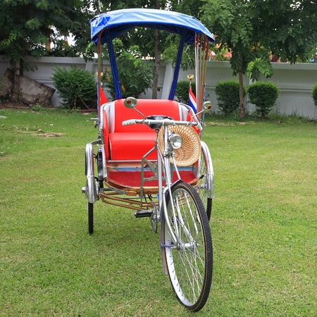 Traditional Thai Rickshaw or tricycle parking on the grassの写真素材