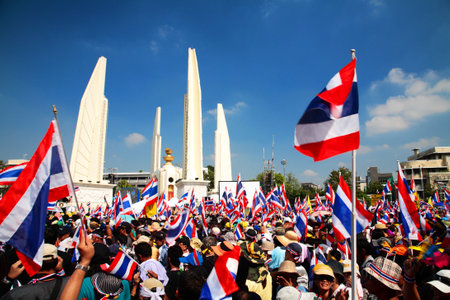 BANGKOK-DEC 1: protesters raise Thai flags at Democracy Monument to anti government amnesty bill on December 01, 2013 in Bangkok, Thailand. Protesters rally to majority government ministries today.のeditorial素材