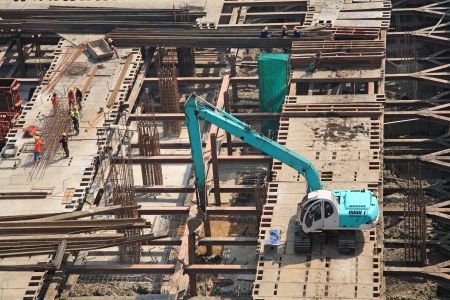 Crane and workers at construction site by aerial viewの写真素材