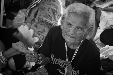 BANGKOK-JAN 13:Unidentified old protestor shake fake clap hand to anti government and ask to reform before election with 'Shutdown Bangkok concept' on Jan 13, 2014 in Bangkok, Thailand.のeditorial素材