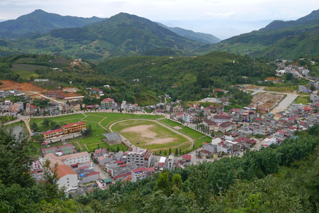 Aerial view of clusters of buildings nestled in valley at Sapa, Vietnamの写真素材