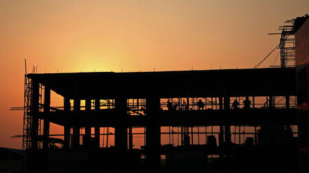 silhouette workers at the construction site at sunsetの写真素材