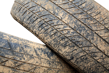 Stack of grunge car tire with brown dirt isolated on whiteの写真素材