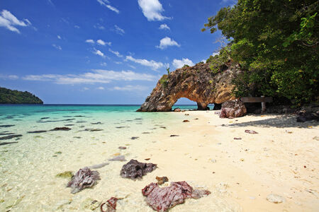 Natural stone arch against blue sky at Kho Khai near Tarutao national park and Koh Lipe in Satun, Thailandの写真素材