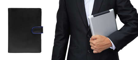 Business man holding tablet vs. organizer book isolated on whiteの写真素材