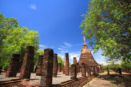 Sukhothai landmark, Wat Chang Lom, elephant statues attached on ancient pagoda against blue sky, Thailandのeditorial素材