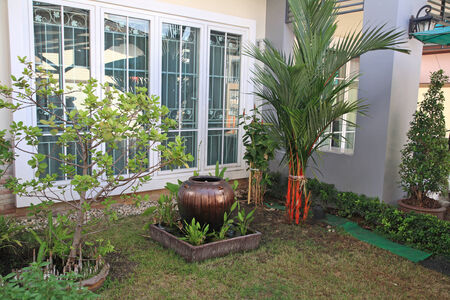 Brown jar fountain decorated in home gardenの写真素材