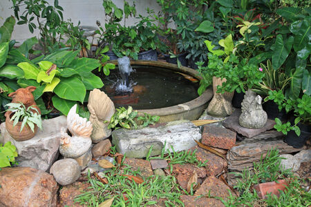 Chicken and pig statues at Fountain with earthenware in gardenの写真素材