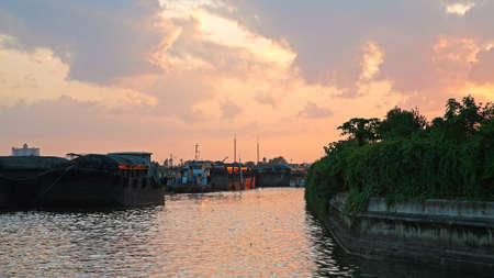 cargo ships floating and parking on Chao Phraya river at twilight skyの写真素材