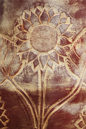 Ornated sunflower carving on wooden boardの写真素材