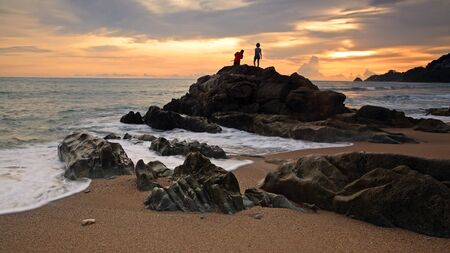 Children fishing at Kalim beach during sunset in Phuket, Thailandの写真素材