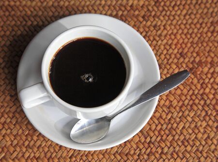 Cup of hot coffee with space on  rattan sheetの写真素材