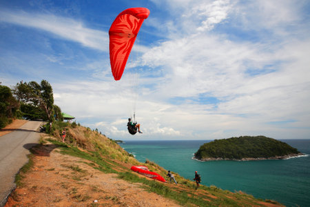 PHUKET,THAILAND - MAY 23, 2015: unidentified man flying by Paramotor to enjoy Andaman sea at windmill viewpoint in Phuket.のeditorial素材