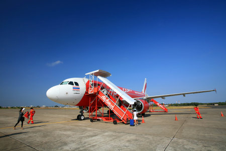 UBON RATCHATHANI, THAILAND - JANUARY 22, 2012: Unidentified passengers walk on runway to get into...