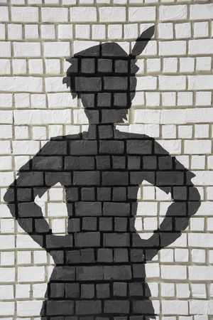 Painted silhouette Peter Pan on white brick wallの写真素材