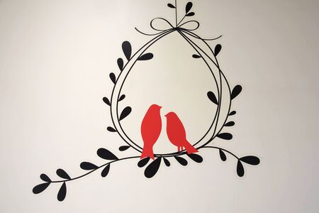 Painted red birds with climber on white wallの写真素材
