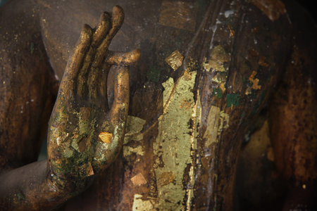 Hand of old Buddha statue making OK gesture sign