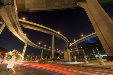 Light trail on street under Bhumibol Bridge before sunrise in Bangkok, Thailand.