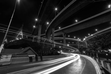 Light trail on road under Bhumibol Bridge in Bangkok, Thailand. Foreign text on the bridge is the...
