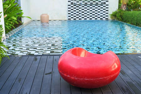 Red seat near cute swimming pool in hotelの写真素材