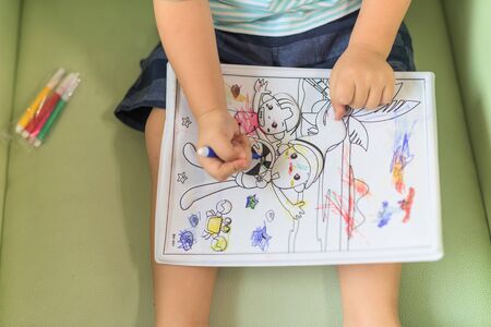 Boy painting cartoon picture by crayon, view from the topの写真素材