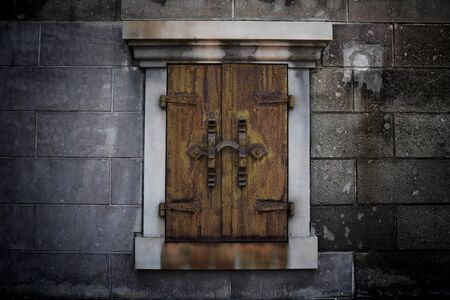 Antique rusty iron window on large brick wallの写真素材