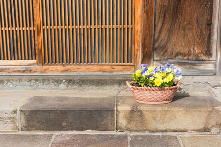 Spring flowers on basket at Traditional Japanese wooden houseの写真素材