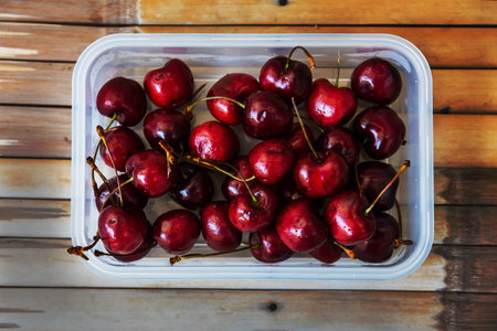 Fresh cherries in box on bamboo table by top view, Healthy eating lifestyle