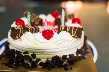 Birthday cake with candles and bokeh light backgroundの写真素材