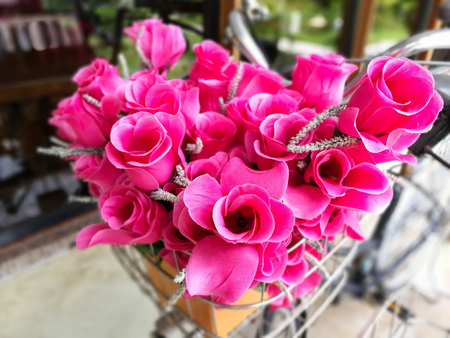 Fake pink flower on bicycle basket. Selective focus at the front flowerの写真素材