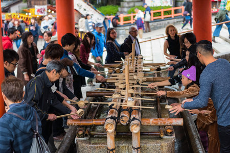 KYOTO, JAPAN - NOVEMBER 20, 2016: Japanese people clean their hands and mouths by holy water before...