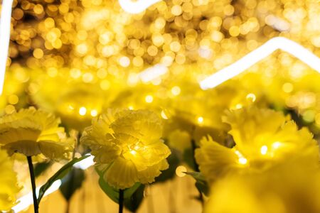 Artificial yellow flowers with Bokeh Background at night for Christmas or x'mas  decorationの写真素材