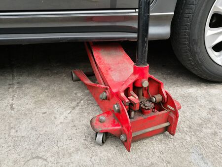 Hydraulic floor jack lift a car in garageの写真素材