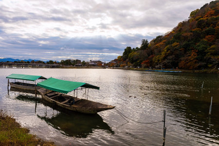 Wooen boat and Togetsukyo bridge with autumn foliage and ray light, Arashiyama, Kyoto, Japanの写真素材
