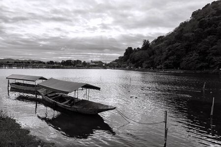 Wooen boat and Togetsukyo bridge with ray light, Arashiyama, Kyoto, Japan. Black and white processの写真素材