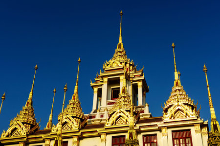 Loha Prasat at Wat Ratchanadda, new golden roof against blue sky, Bangkok, Thailand