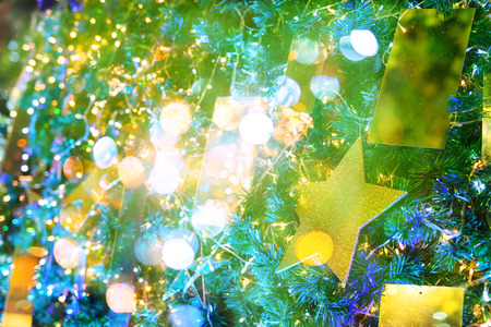 Christmas tree with golden star decoration overlay by defocused light bokeh abstractの写真素材