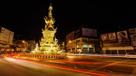 CHIANGRAI, THAILAND - JANUARY 8, 2017 : Light trail at Clock Tower Designed by Chalermchai Khosit Pipat, with King Bhumibol billboard.のeditorial素材