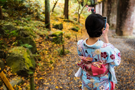 Rear view of Japanese girl in Traditional kimono selfie by smartphone in Nanzen-ji temple, Kyoto, Japanのeditorial素材