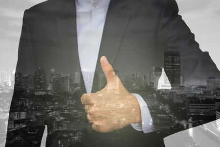 Double exposure, Business man hand with thumb up overlay by modern construction buildingの写真素材