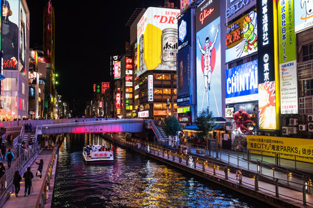 OSAKA, JAPAN - NOVEMBER 24, 2016: Tourist boat on the canal to see famous Glico advertisement Billboards in Dotonbori, Osaka's primary tourist destinations.のeditorial素材