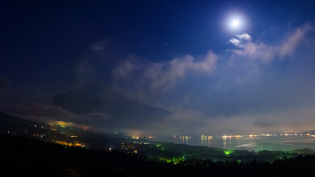 Mount Fuji and lake Yamanaka from Fuji Panoramadai viewpoint at night with stars, mist, and moon, Yamanashi, Japanの写真素材