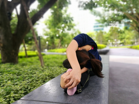 Yoga woman perform arm and leg stretching exercise at green park garden backgroundの写真素材