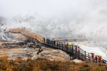 People visit Jigokudani hell valley with heavy rain, Noboribetsu, Hokkaido, Japan.のeditorial素材